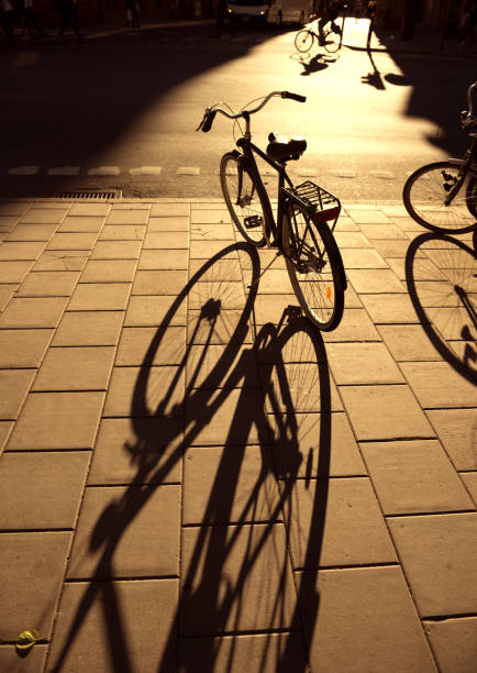 An old bike that has back flat tire parked by the urban road in the evening of the day and waited to fix later. Colour and lens flare edited. Soft focus