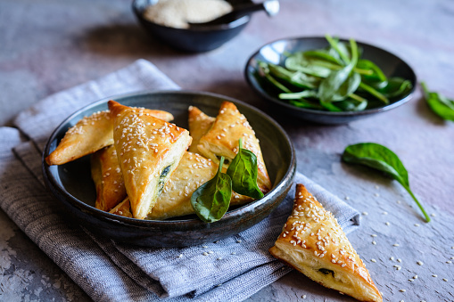 Freshly baked Spanakopita triangles stuffed with spinach and Feta cheese