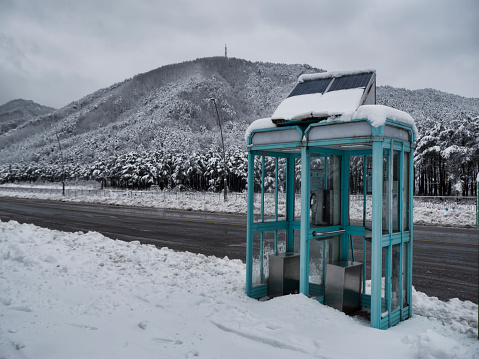 Telephone booth on a snow-covered mountain road, South Korea