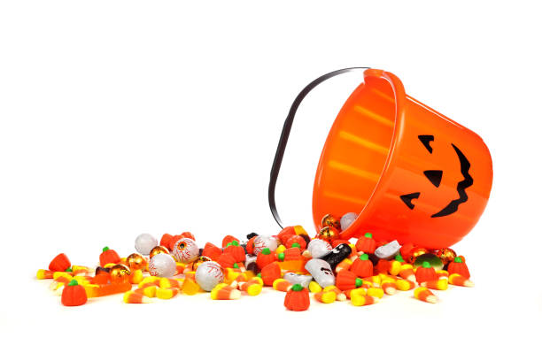 istock Halloween Jack o Lantern candy collector with spilling candy over white 1040023012