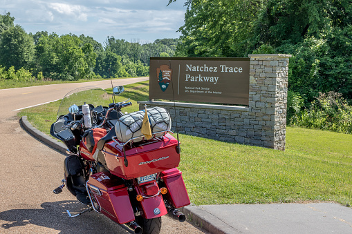 Natchez, MS, USA--5 April 15: A motorcycle with camping gear strapped on, setting at the southern entrance to the Natchez Trace Parkway, in Mississippi, USA.
