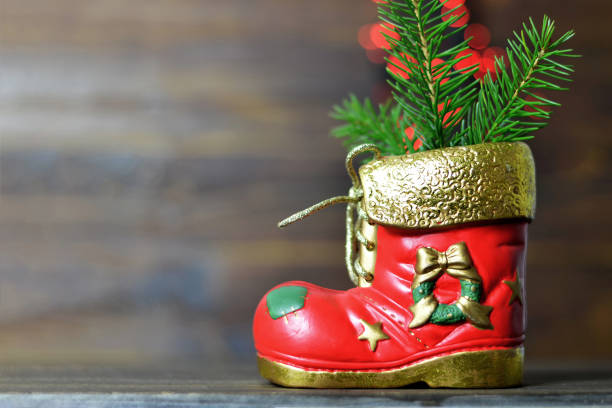 istock Christmas boot with Christmas tree branches and blurred lights in background 1040027326