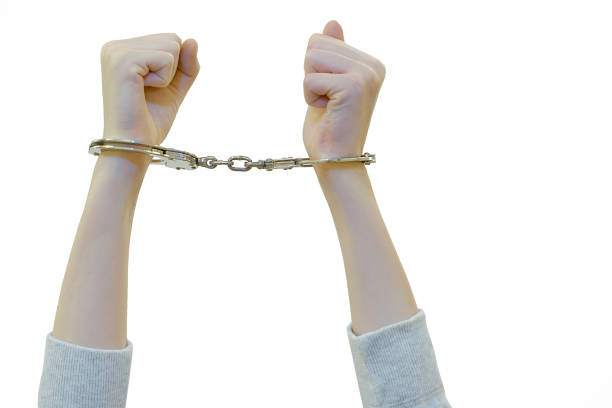 istock Criminal hands locked in handcuffs. Close-up view 1040028112