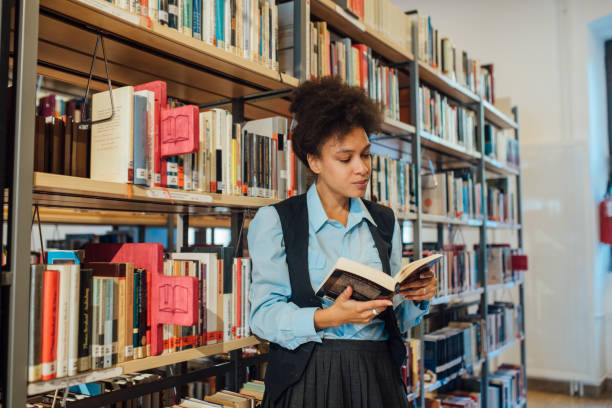 istock Woman reading a book in the library 1040030186