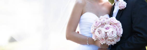 Bride And Groom In Romantic Pose After Marriage Newly married bride and groom posing with veil in a soft dreamy image in a garden bride holding bouquet stock pictures, royalty-free photos & images