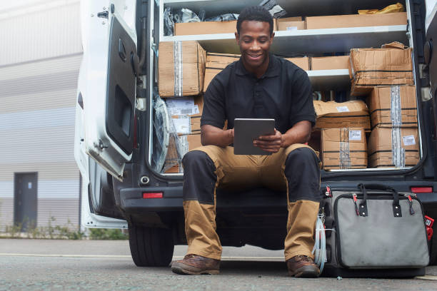 istock Service engineer using digital tablet sat at the back of his van 1040037392