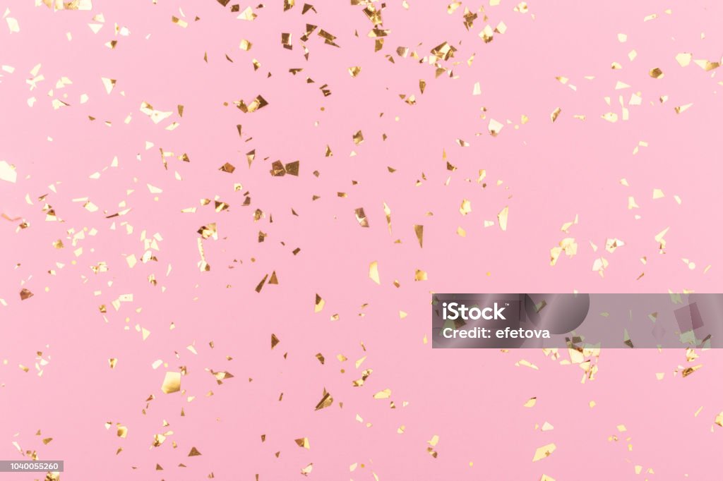 Golden sparkles on pink Golden sparkles on pink pastel trendy background. Festive backdrop for your projects. Confetti Stock Photo