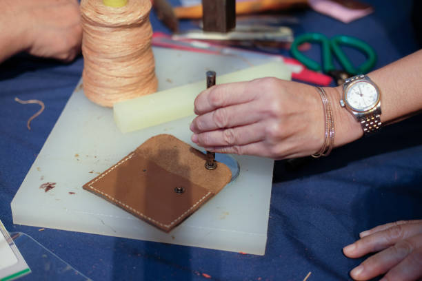 istock craftsman pinching button on leather bag. handmade DIY handicraft 1040084668