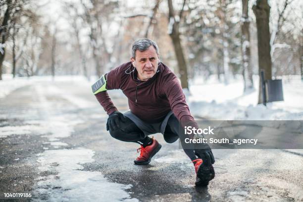 Man Warming Up Before Jogging Stock Photo - Download Image Now - Winter, Exercising, Senior Adult