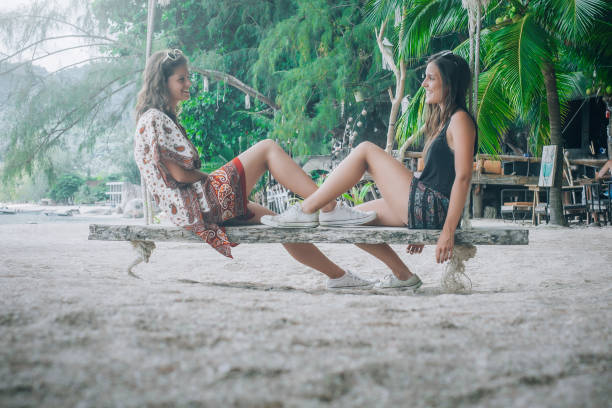 istock Two happy girlfriend swinging on the swing at tropical beach 1040123816