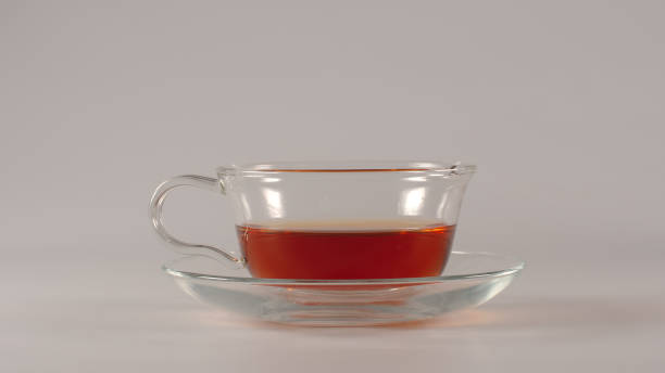 istock Glass with half of black tea on a white background 1040144620