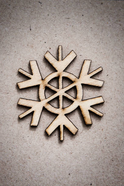istock Wooden Decorative Snowflake on Craft Paper Background 1040174484