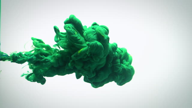 Slow motion green blue and yellow ink flow in water.