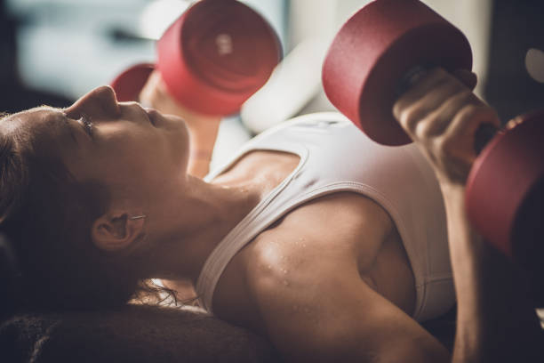istock Athletic woman having a weight training on a bench in a gym. 1040220582