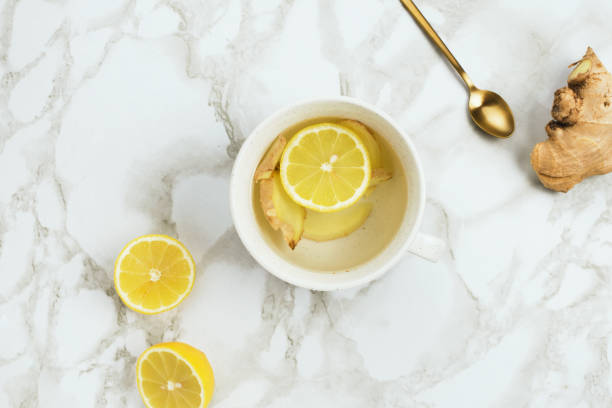 flatlay of healthy drink with lemon and fresh ginger root on marble background, natural cold or sore throat - ginger tea cup cold and flu tea imagens e fotografias de stock
