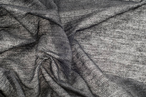 istock fabric gray black with white inserts metallic gold Thin white yarns are drawn on a black background, and thicker white yarns, twisted with a small amount of gold, create an almost spattered appearance 1040245088