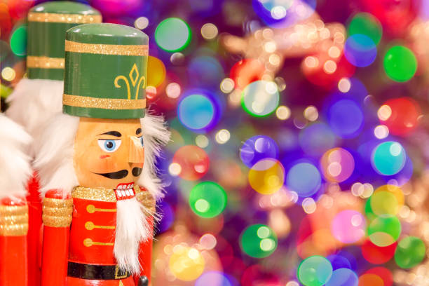 istock Soldier nutcracker statues standing in front of decorated Christmas tree with bokeh lights. 1040269930