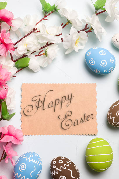 istock Painted easter eggs and branches of spring sakura closeup on a light blue background with space for congratulation 1040270198