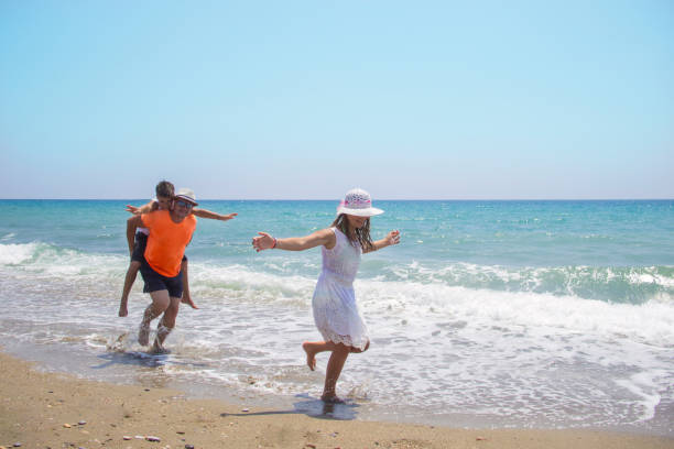 istock Father with children having fun on the beach at the day time. 1040275420