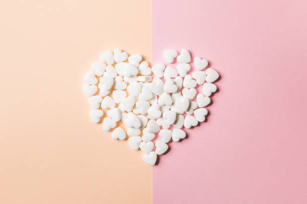 istock Tablets in the form of hearts on a double pink and solid background. 1040284710