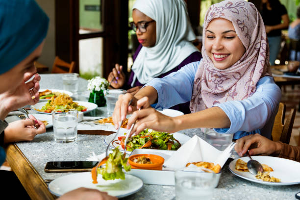 amis de femmes islamiques à manger ainsi que du bonheur - arab ethnicity photos et images de collection