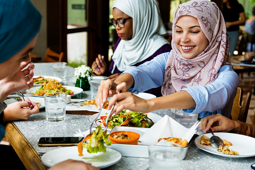 Islamic women friends dining together with happiness