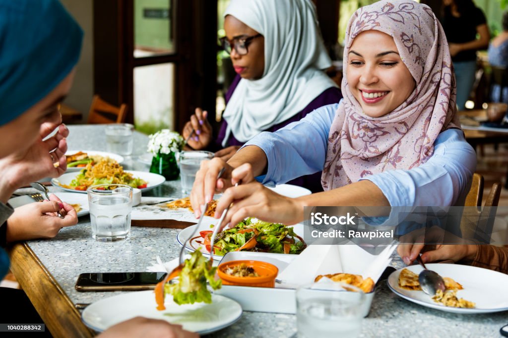 Islamic women friends dining together with happiness Eating Stock Photo