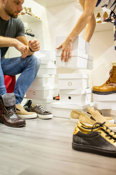istock Man choosing shoes with clerk's assistance 1040299104
