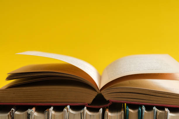 노란색 배경, 나무 테이블에 대 한 hardback 책에 오픈 책. 교육 및 학습 배경입니다. 학교에 다시 공부. 텍스트를 위한 공간 복사 - legal system law book dictionary 뉴스 사진 이미지