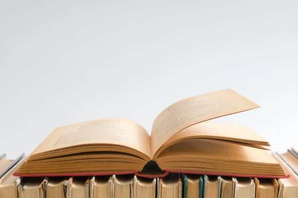 istock Open book on white background, hardback books on wooden table. Education and learning background. Back to school, studying. Copy space for text 1040308368