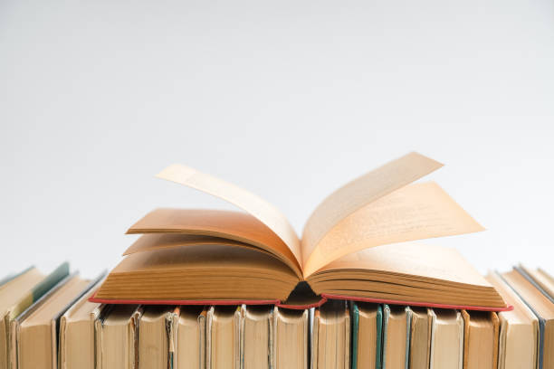 istock Open book on white background, hardback books on wooden table. Education and learning background. Back to school, studying. Copy space for text 1040308396