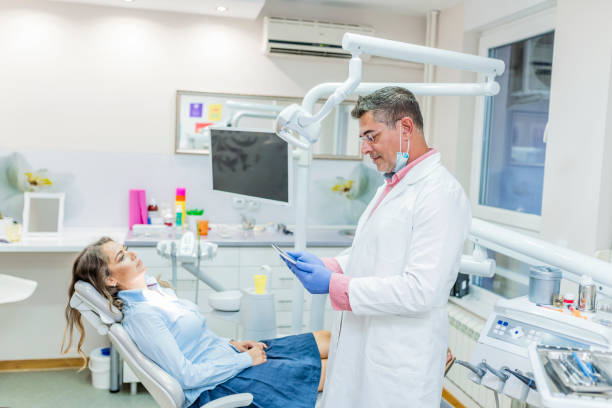 istock Dentist discussing over digital tablet with male patient 1040319138