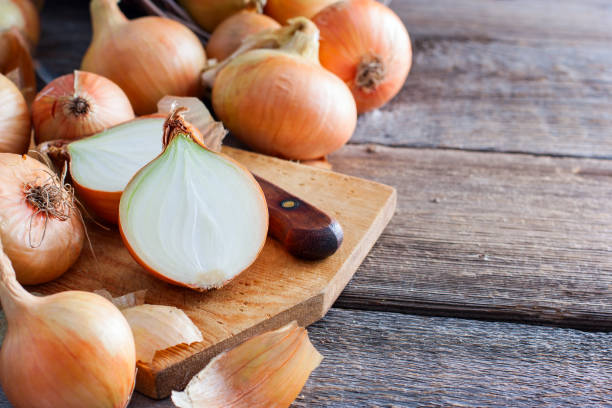 istock Large onion harvest in a wicker basket. Bulb onion is rich in vitamins, useful spring. Onion peel on a wooden background. Large onions can be seen from above. 1040320324