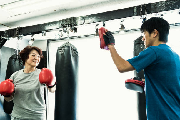 수석 성인 여자 복싱 체육관에서 코치와 함께 훈련 - boxing women gym aspirations 뉴스 사진 이미지