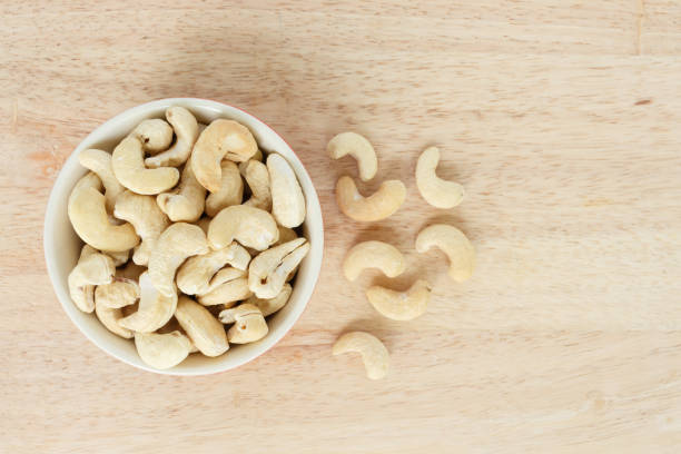 istock cashew in white bowl top view on wooden background. 1040324634