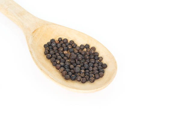 istock peppercorns in spoon heap on white background. 1040325314