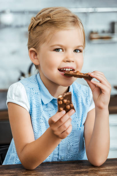 istock cute happy kid eating delicious chocolate with hazelnuts and smiling at camera 1040332914