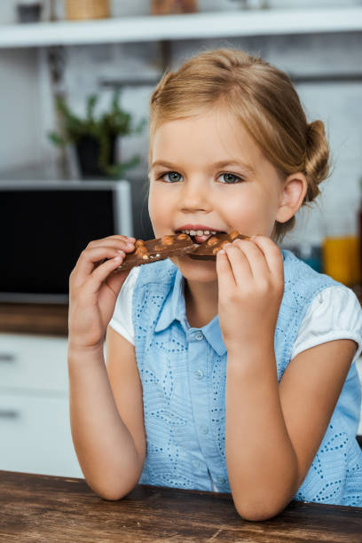 istock adorable child eating delicious chocolate with hazelnuts and smiling at camera 1040332926