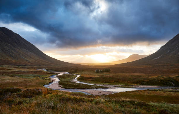 Glencoe view over the vally Glencoe view of the vally during a sunrise, with a river in the foreground scottish highlands stock pictures, royalty-free photos & images