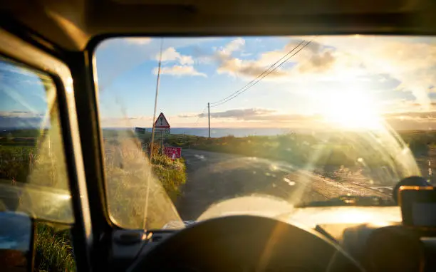 A view out of a landrover defender on the road to St. Abbs. It's early in the morning and it's sunny.