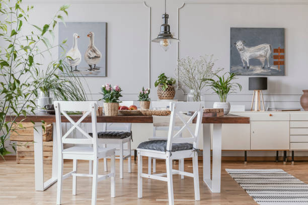istock White chairs at table with flowers in rustic dining room interior with lamp and posters. Real photo 1040342996