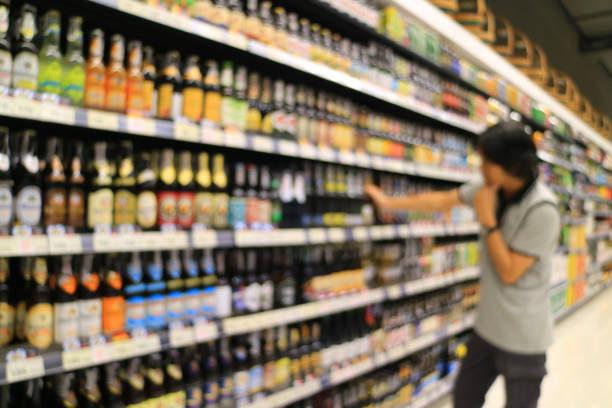 da tomada de foco de um homem a olhar para as mercadorias na prateleira do supermercado em uma loja de varejo - beer wine drink collection - fotografias e filmes do acervo