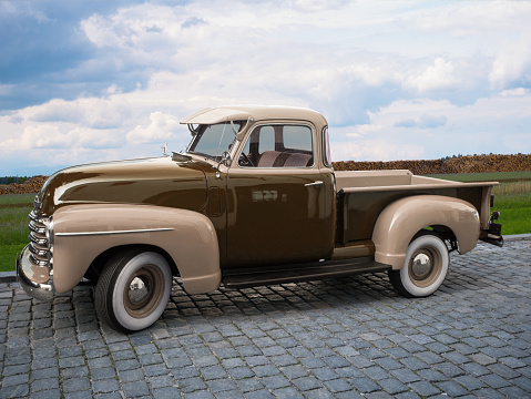Classic pick-up oldtimer in light brown and dark brown on cobblestones