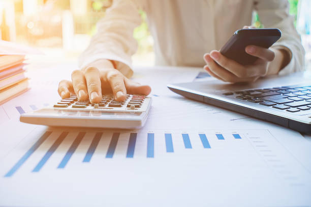 istock woman working with calculator, business documcalculator; paycheck; accounting; budgeting; save; business; desk; plan; businessman; laptop; statement; paperwork; document; work; paper; sheet; market; shine; economics; income; concept; asset; deposit; succe 1040376046