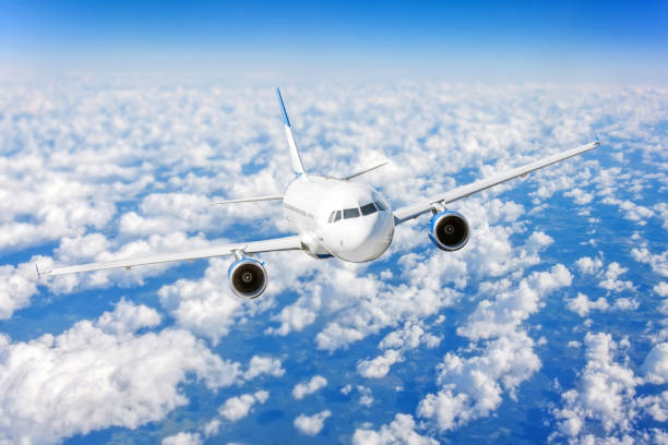 istock Commercial airplane flying over bright blue sky and white clouds. 1040385910