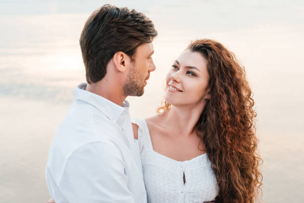 istock smiling romantic couple looking at each other and hugging on seashore 1040391000