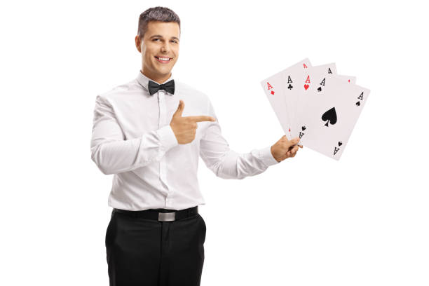 istock Young guy in a tux holding playing cards and pointing 1040394510