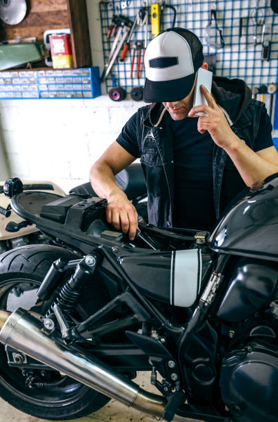 istock Mechanic talking phone while fixing motorbike 1040396146