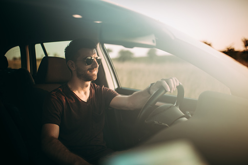 Young man drive his car on the road