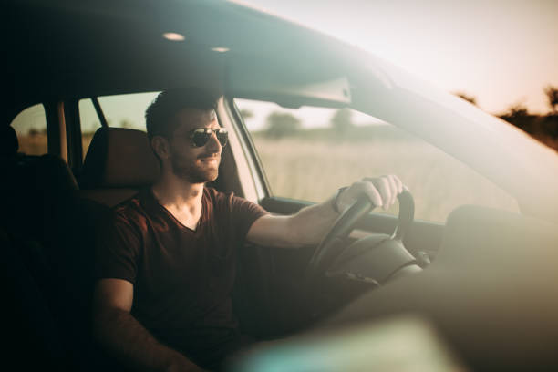 homem dirigindo em pôr-do-sol - car driving inside of indoors - fotografias e filmes do acervo